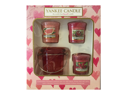 A box of Yankee Candles with pink hearts. Inside the box is a vacuum formed tray holding the candles in place.